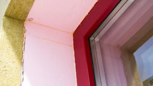 Encuentro de la ventana con paneles de aislamiento rosa y lana de roca