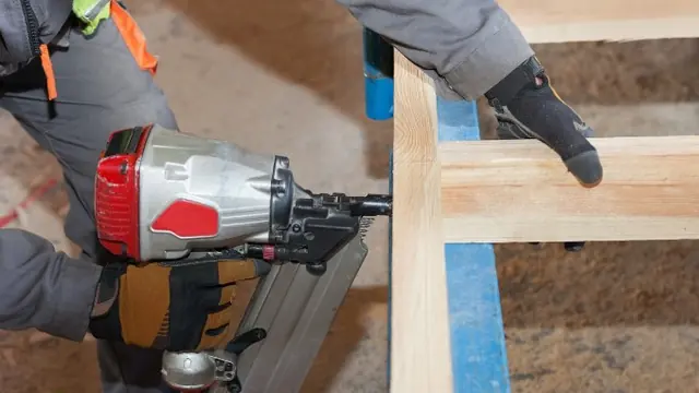 Operario con clavadora neumática trabajando en una estructura de madera